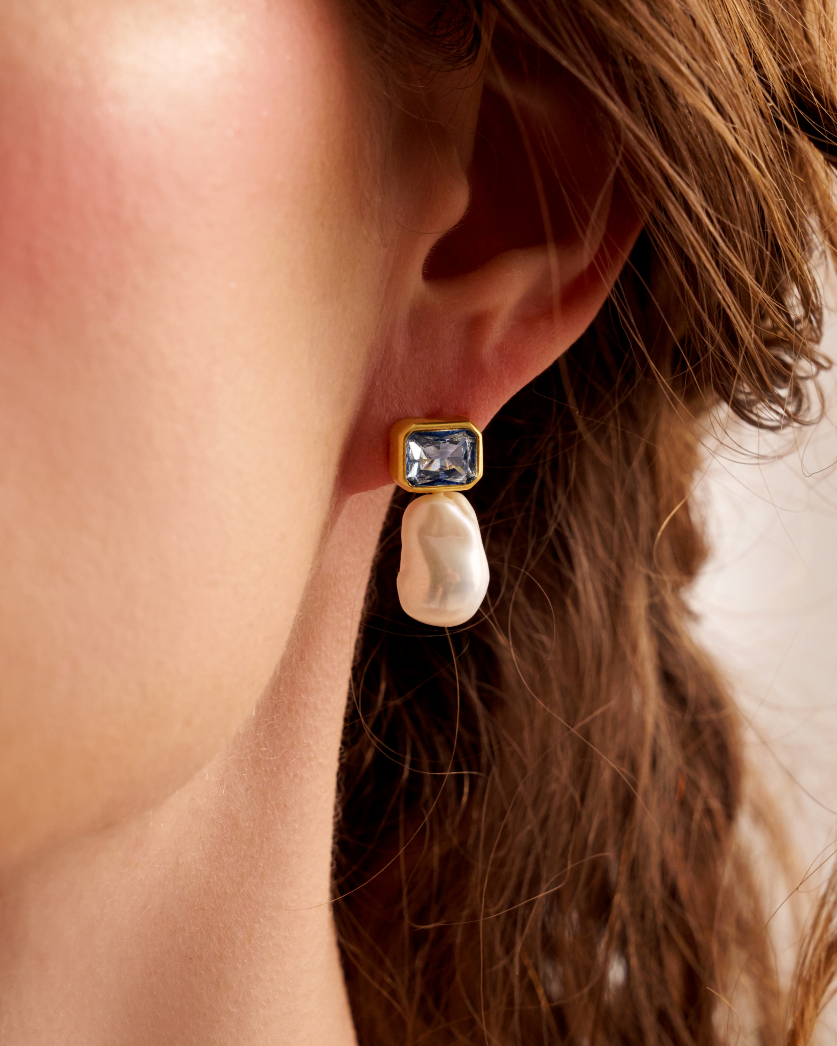 Close-up of woman wearing pearl drop earrings