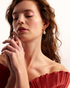 Woman wearing gold pearl statement earrings