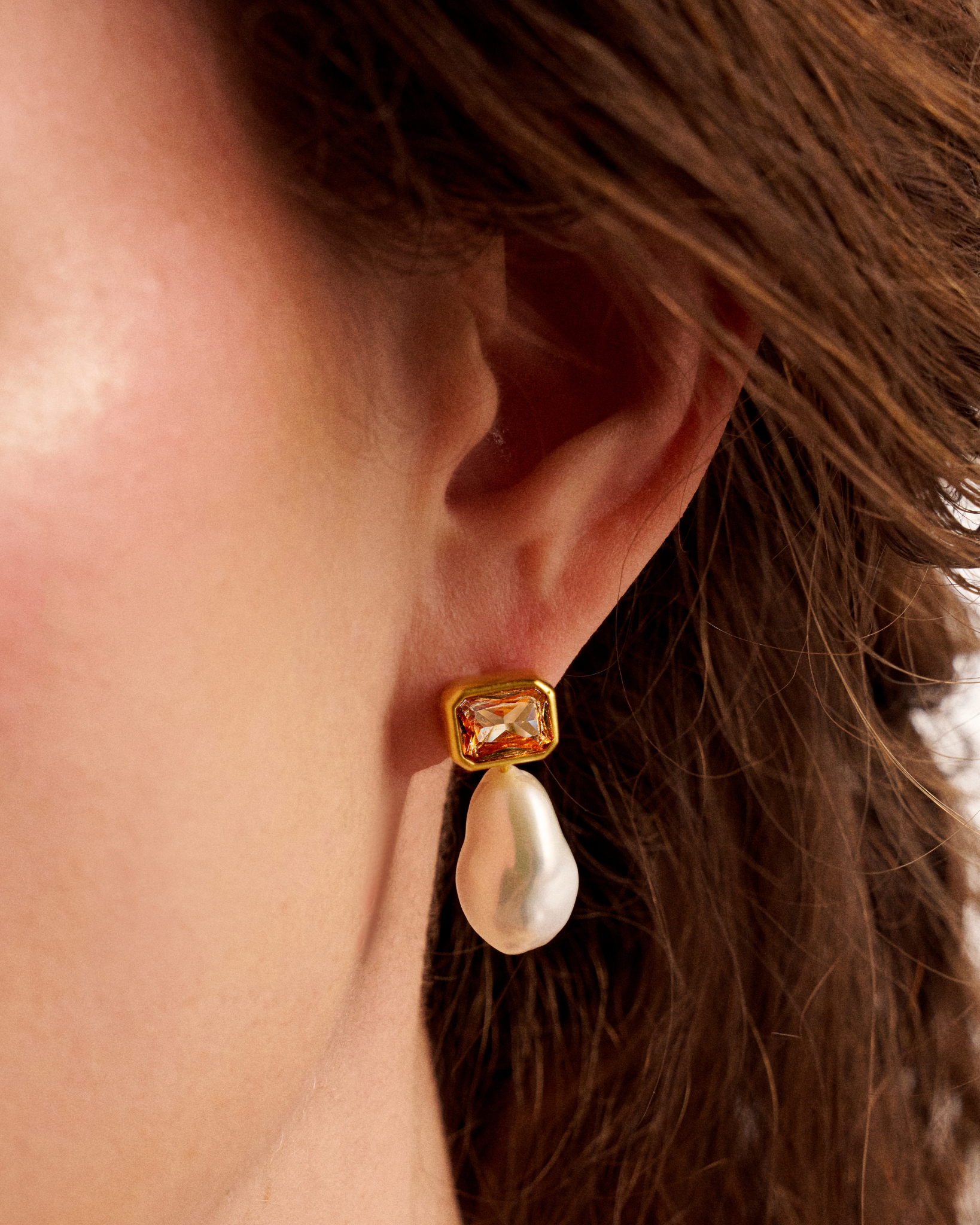 Close-up of woman wearing pearl drop earrings