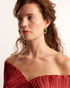 Woman wearing gold geometric gemstone earrings