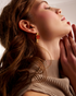 Close-up portrait with gold gemstone earrings
