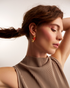 Woman wearing gold geometric gemstone earrings