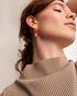 Woman wearing modern gold statement earrings