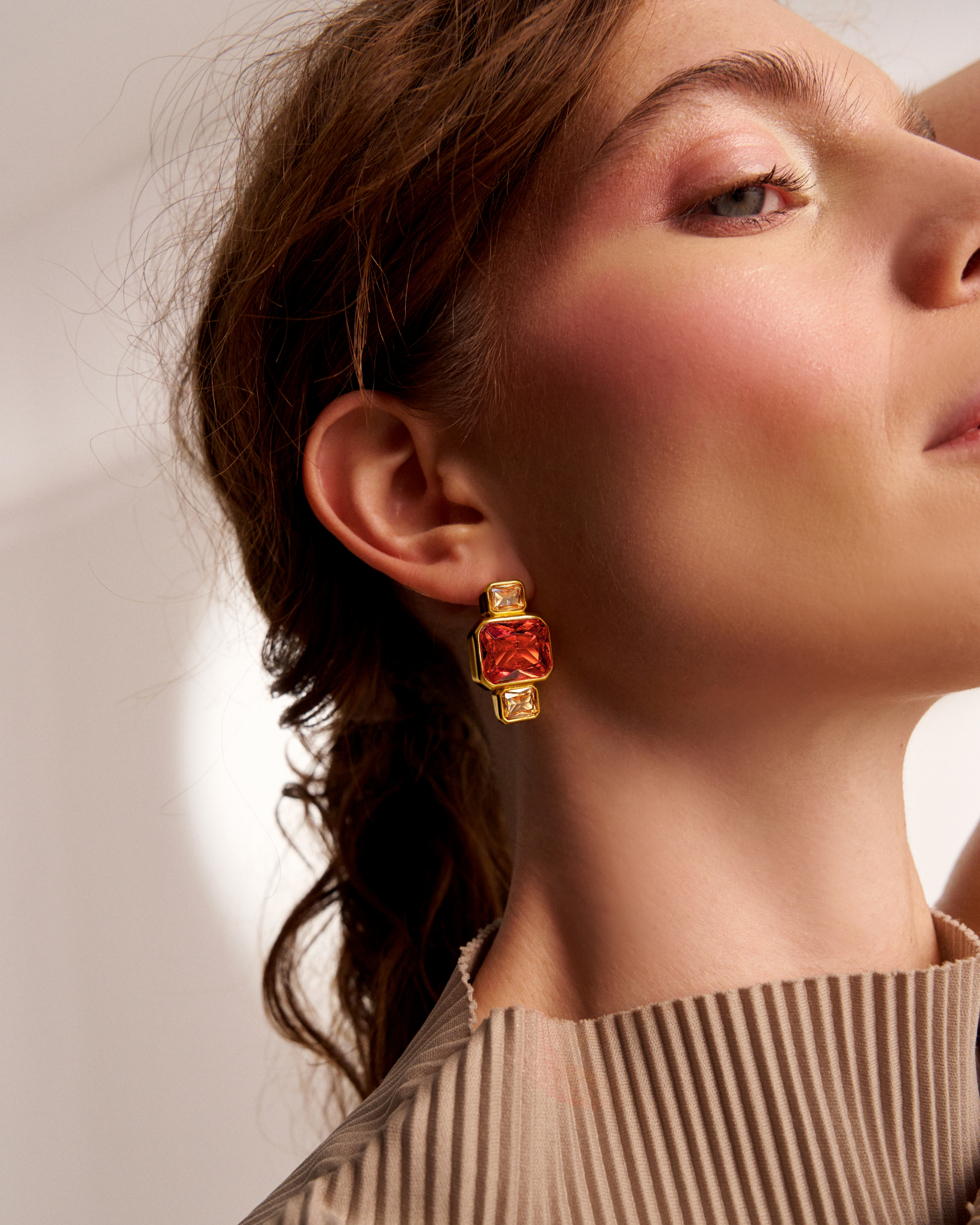 Side profile of gold geometric gemstone earrings