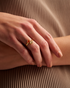 Close-up of gold open gemstone ring on hand