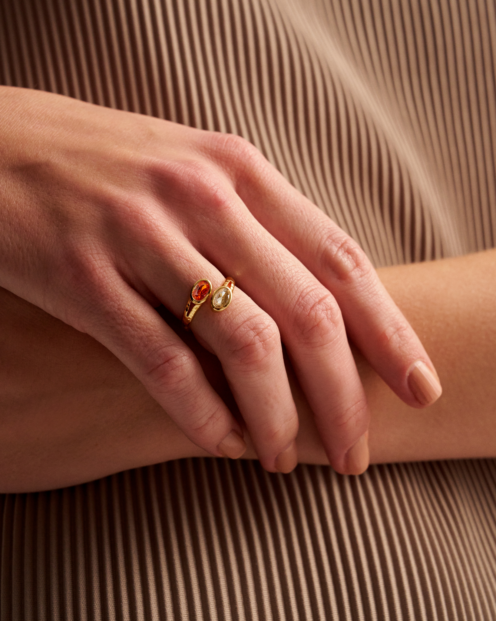 Close-up of gold open gemstone ring on hand