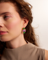 Woman wearing gold geometric gemstone earrings