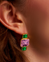 Close-up of gold geometric earrings with pink and green gemstones