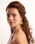 Gold floral statement earrings on model