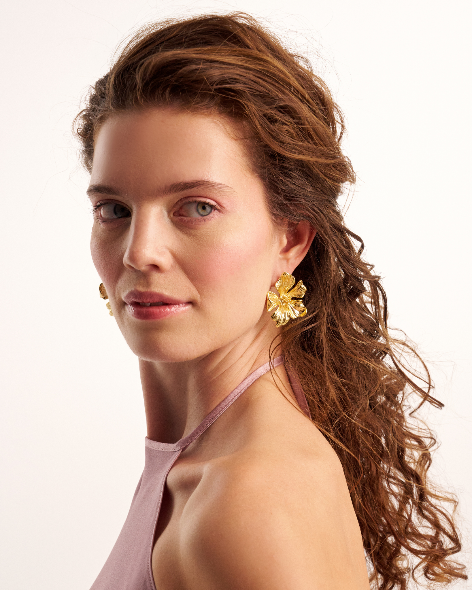 Gold floral statement earrings on model