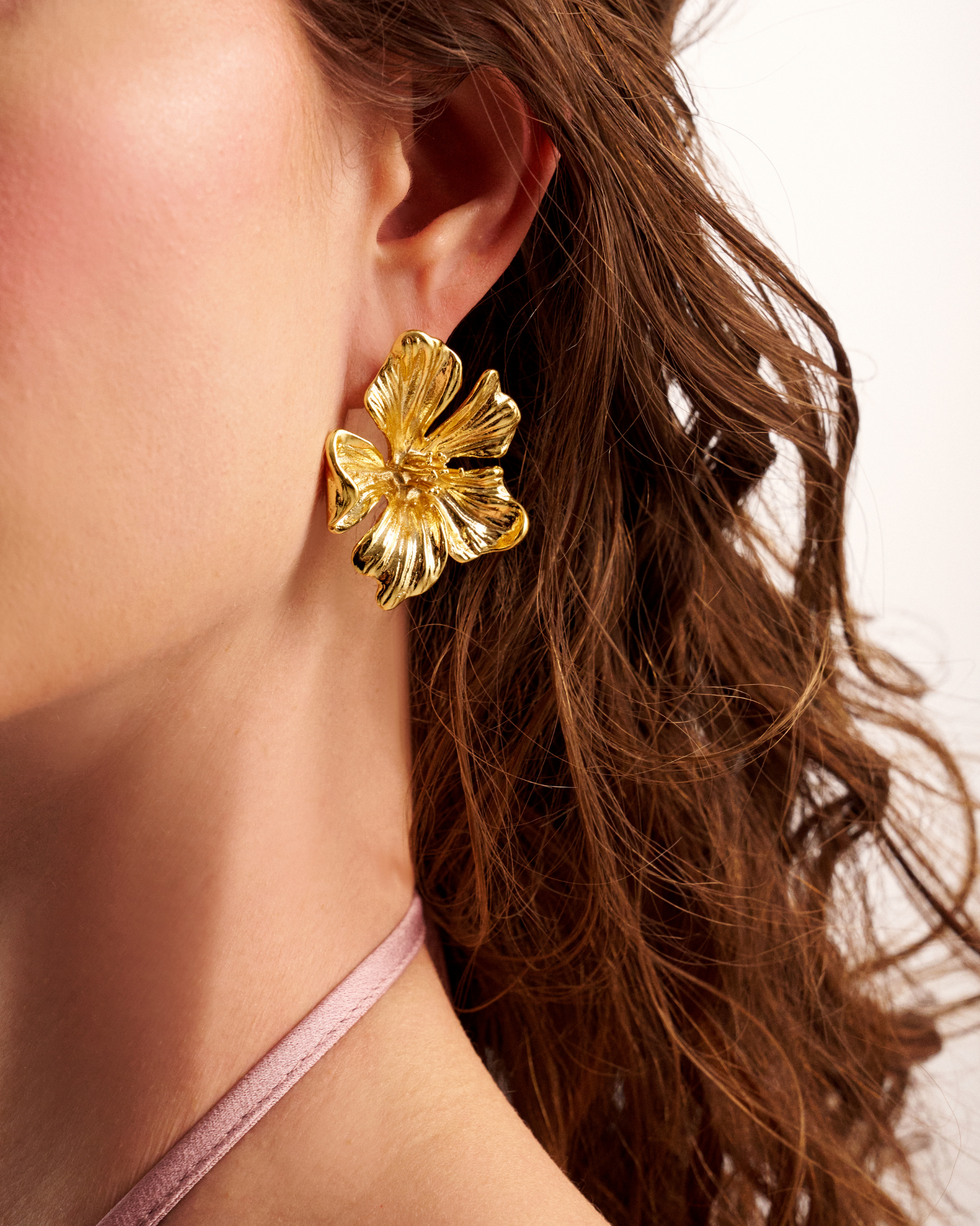 Bold gold flower earrings close-up