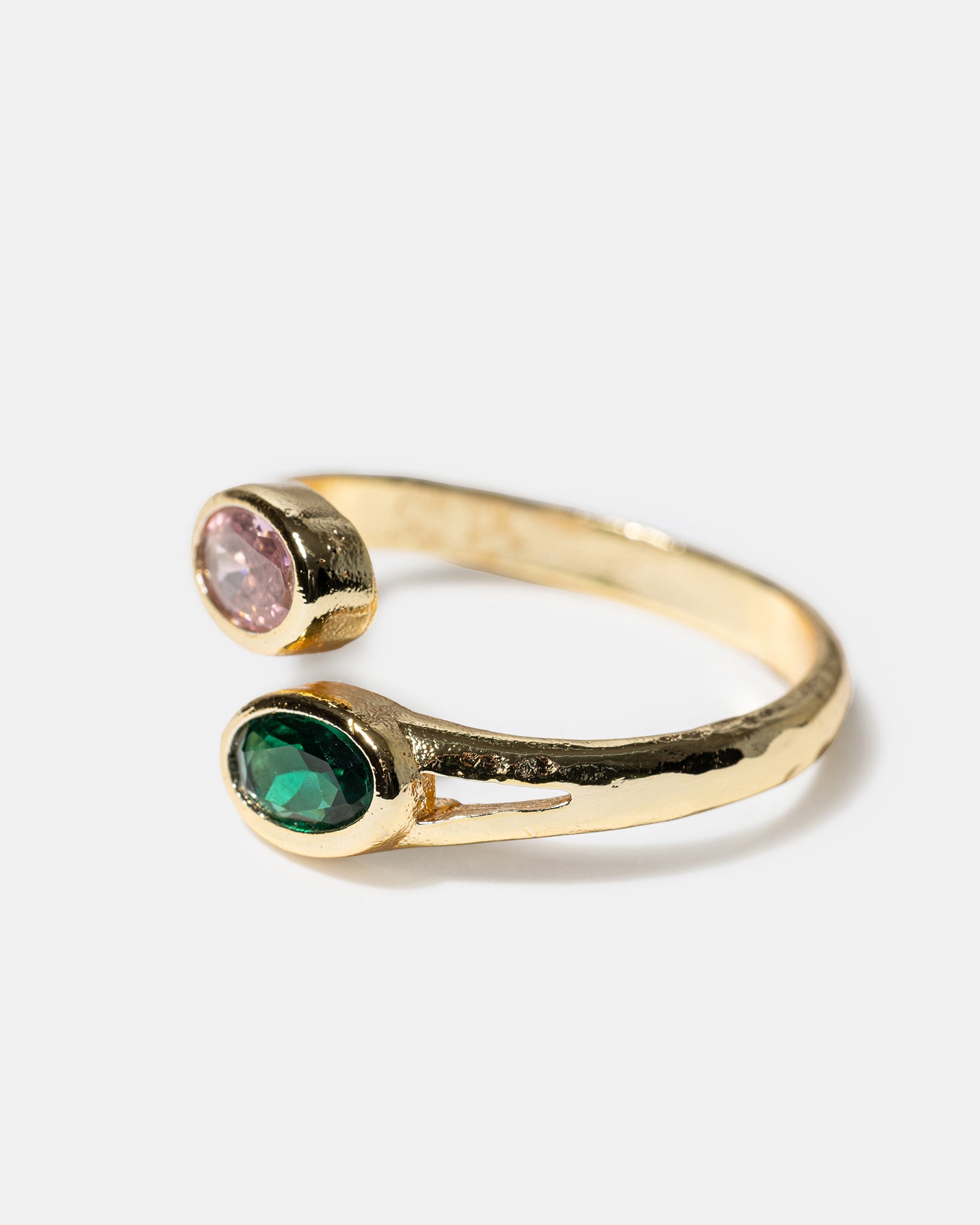 Side view of gold open ring with pink and green gemstones