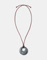 Black rhodonite donut pendant necklace on adjustable burgundy cord