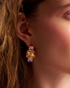 Close-up of woman wearing gold gemstone earrings