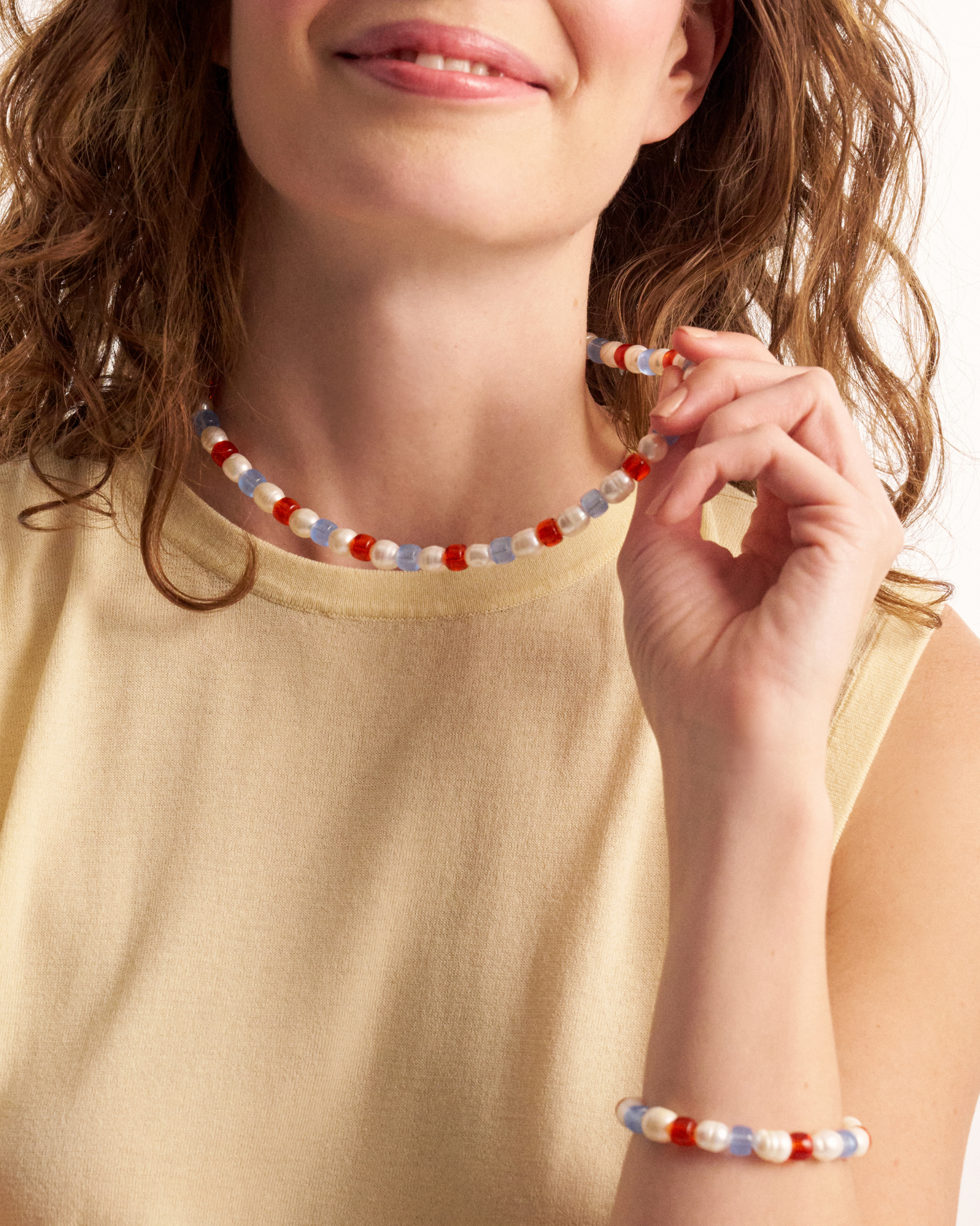 Woman wearing matching colorful pearl necklace and bracelet