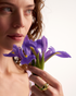 Woman wearing gold dome cocktail ring with purple iris flowers