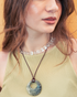 Woman wearing black rhodonite donut pendant necklace