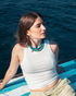 Woman wearing turquoise statement necklace by the sea