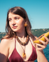 Woman wearing yellow calcite pendant necklace outdoors in summer