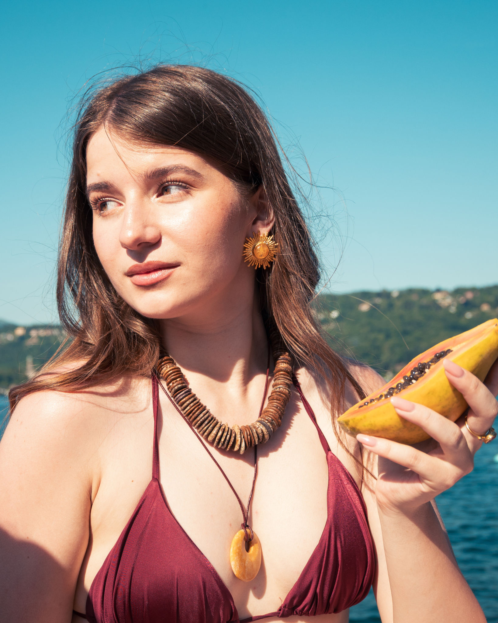 Woman wearing yellow calcite pendant necklace outdoors in summer