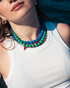 Woman wearing turquoise gemstone necklace with red chili pepper charm